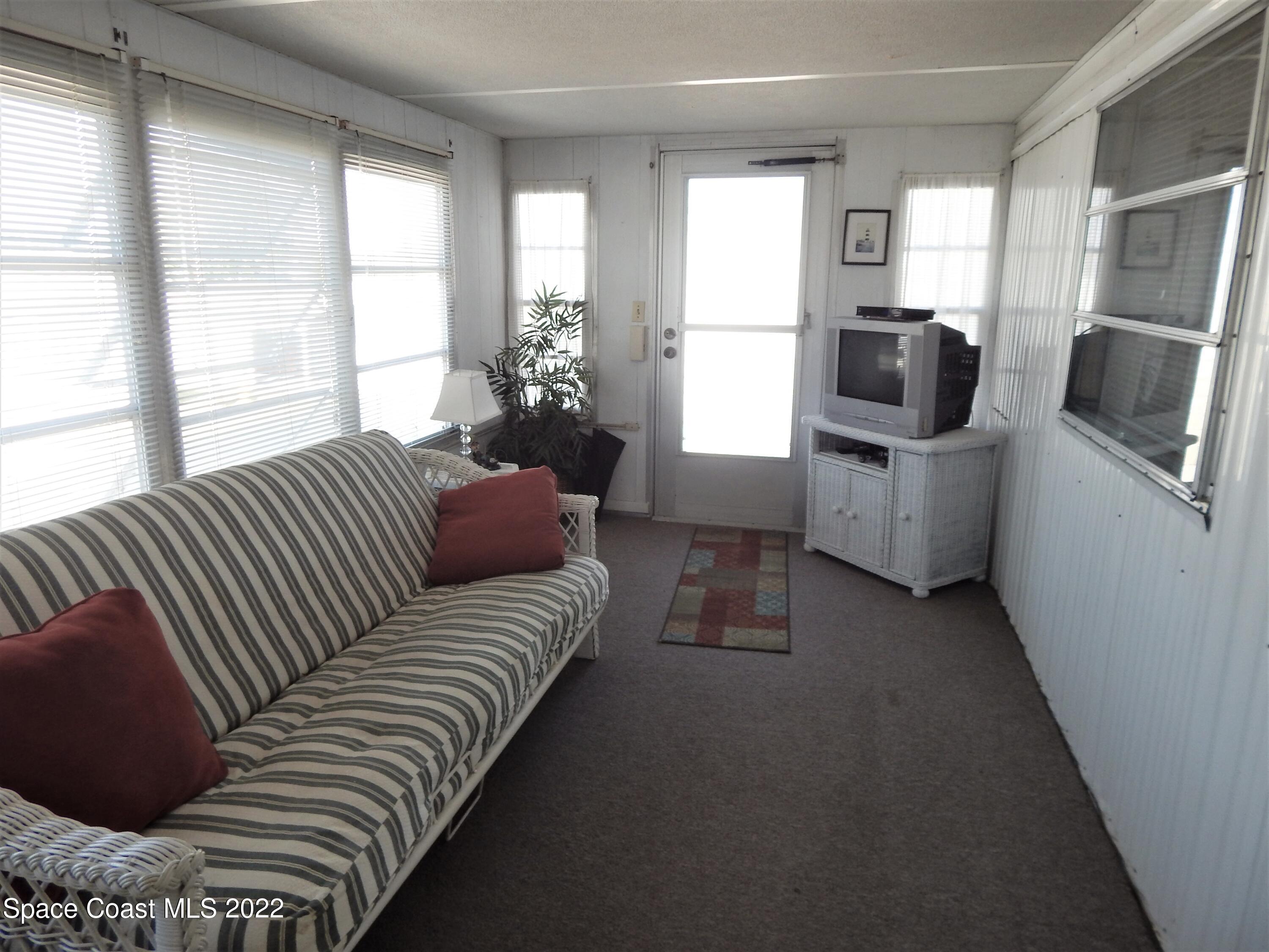 3112 Tangelo Drive Northeast Palm Bay, FL 32905 - Photo 15 of 42 a living room with furniture a flat screen tv and windows