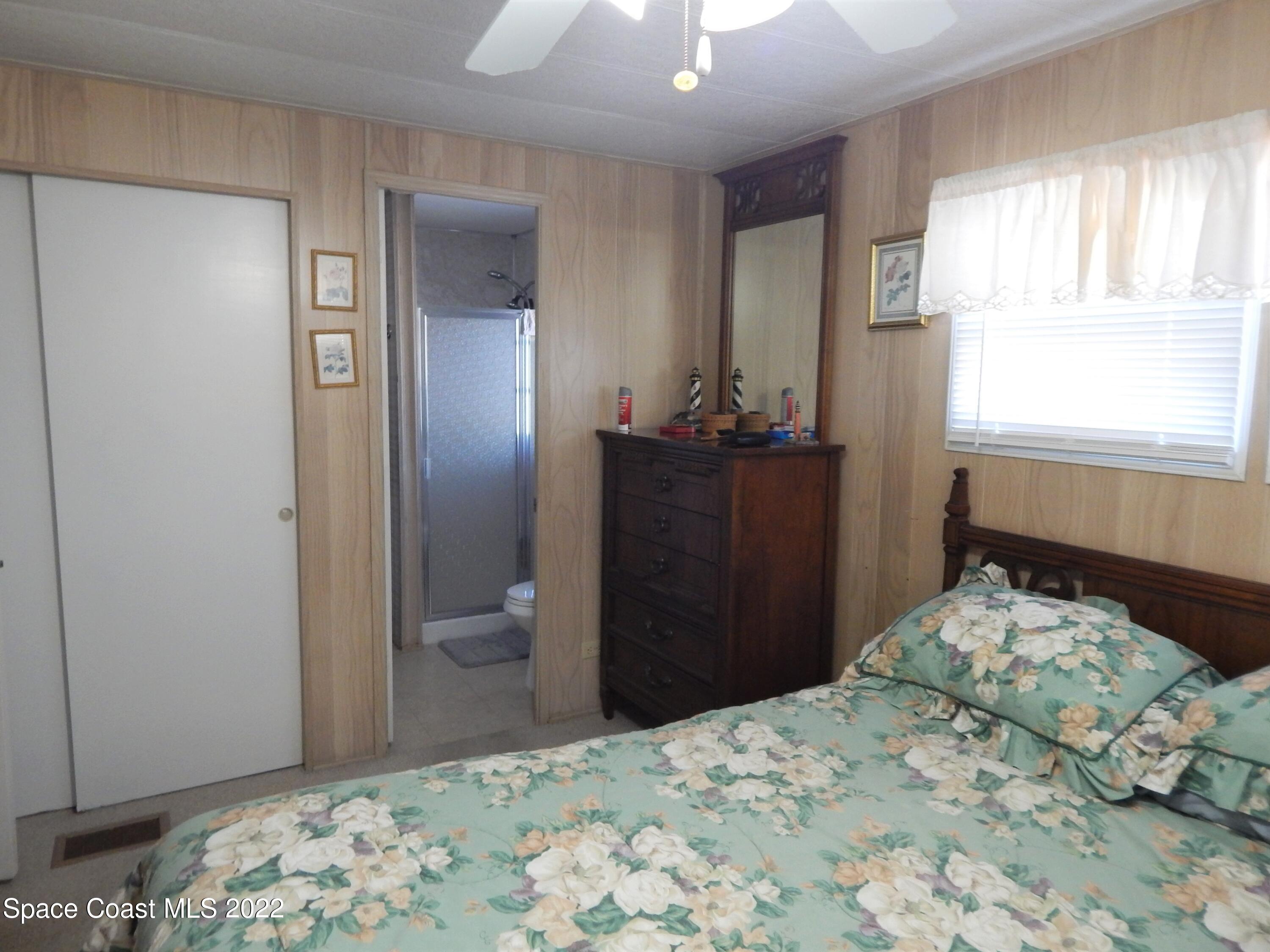 3112 Tangelo Drive Northeast Palm Bay, FL 32905 - Photo 17 of 42 a bedroom with a bed and a dresser in it