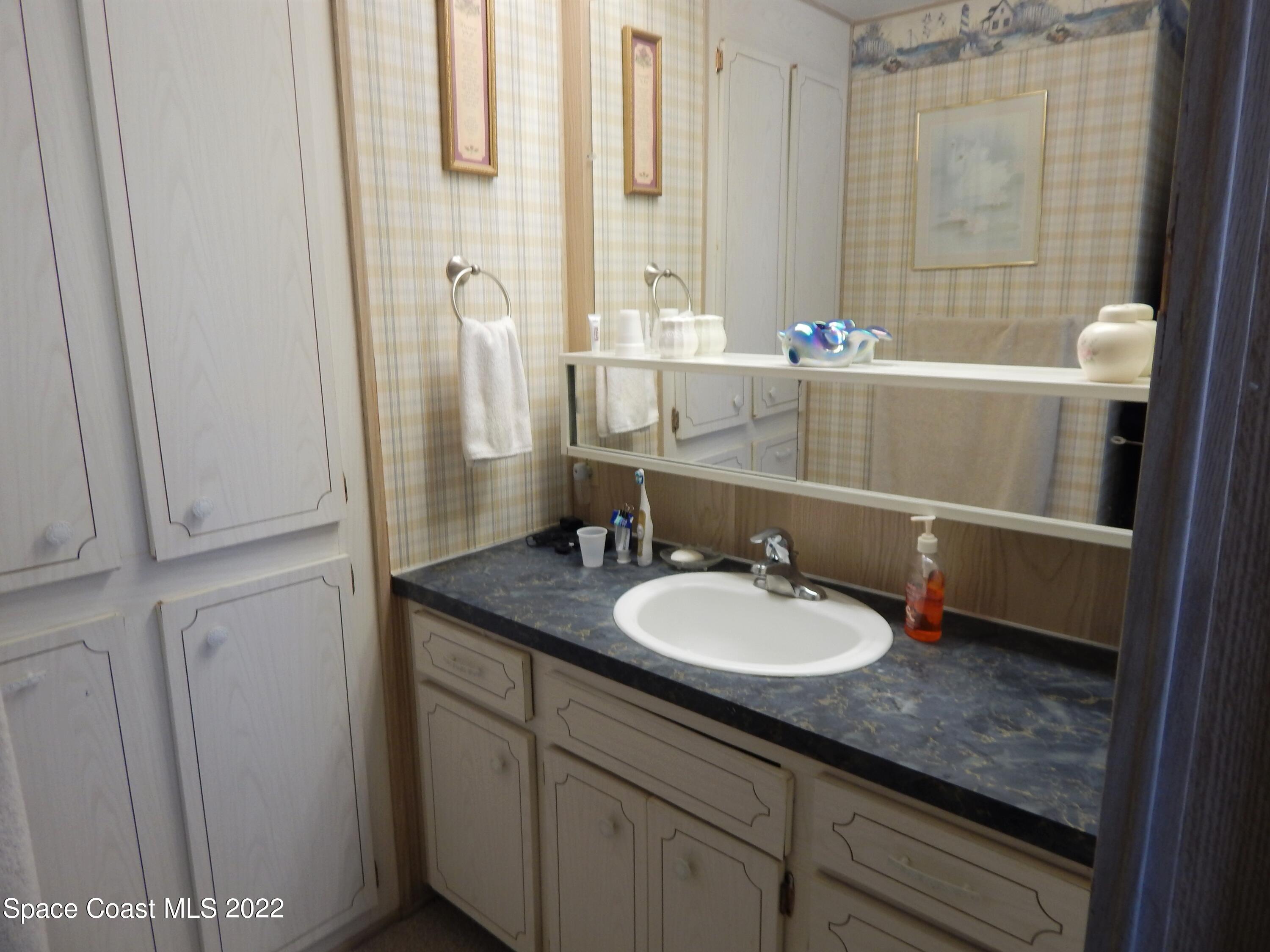 3112 Tangelo Drive Northeast Palm Bay, FL 32905 - Photo 21 of 42 a bathroom with a granite countertop sink and a mirror