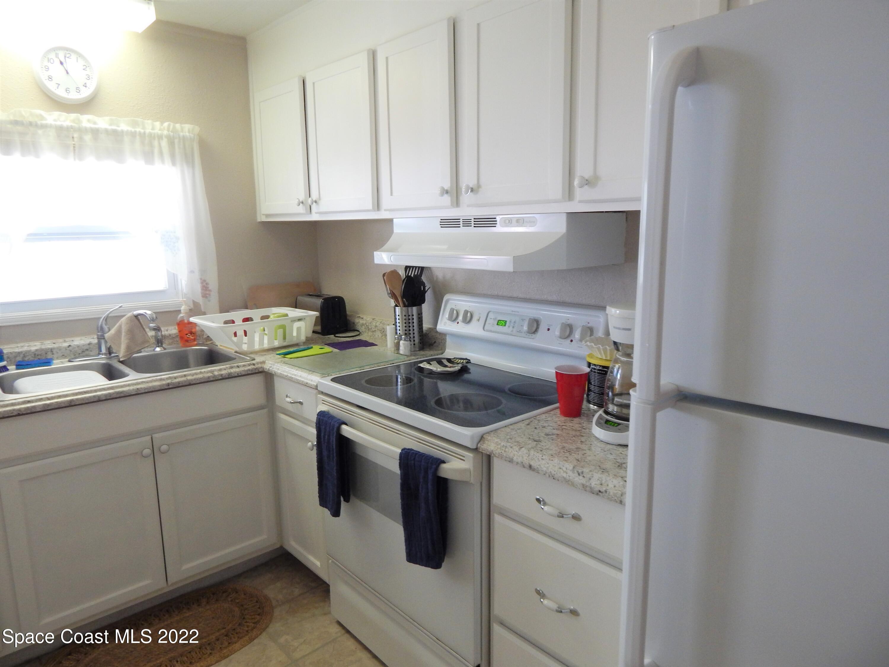 3112 Tangelo Drive Northeast Palm Bay, FL 32905 - Photo 8 of 42 a kitchen with stainless steel appliances granite countertop a sink stove and cabinets