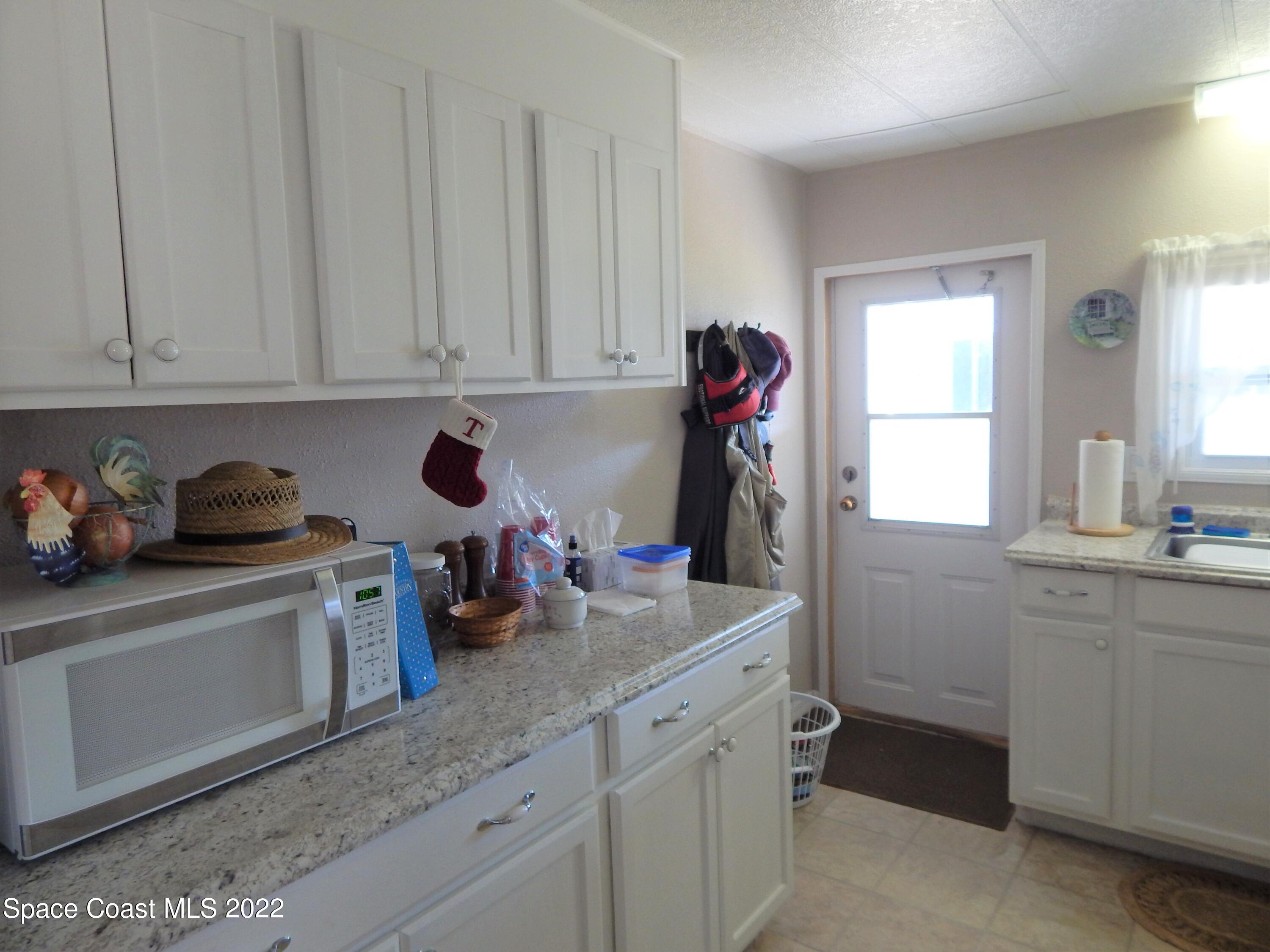3112 Tangelo Drive Northeast Palm Bay, FL 32905 - Photo 9 of 42 a kitchen with white cabinets and sink