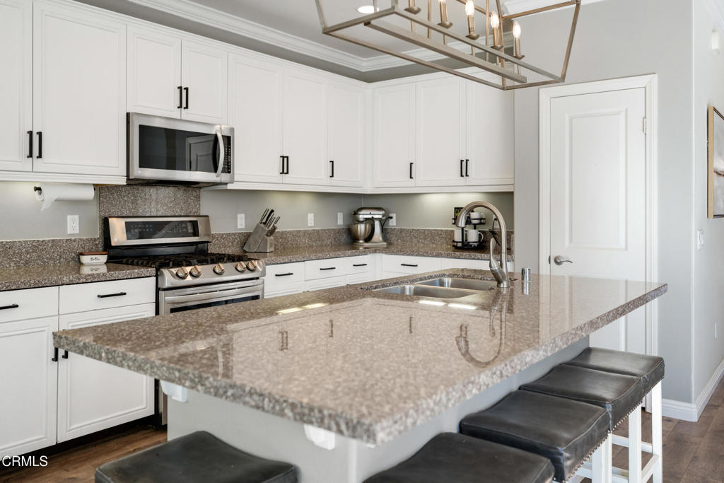 668 Whalen Way Oxnard, CA 93036 - Photo 10 of 57 a kitchen with stainless steel appliances granite countertop a sink a stove and a microwave