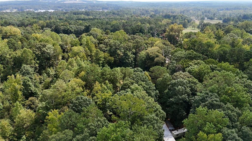 an aerial view of residential house with outdoor space and trees all around