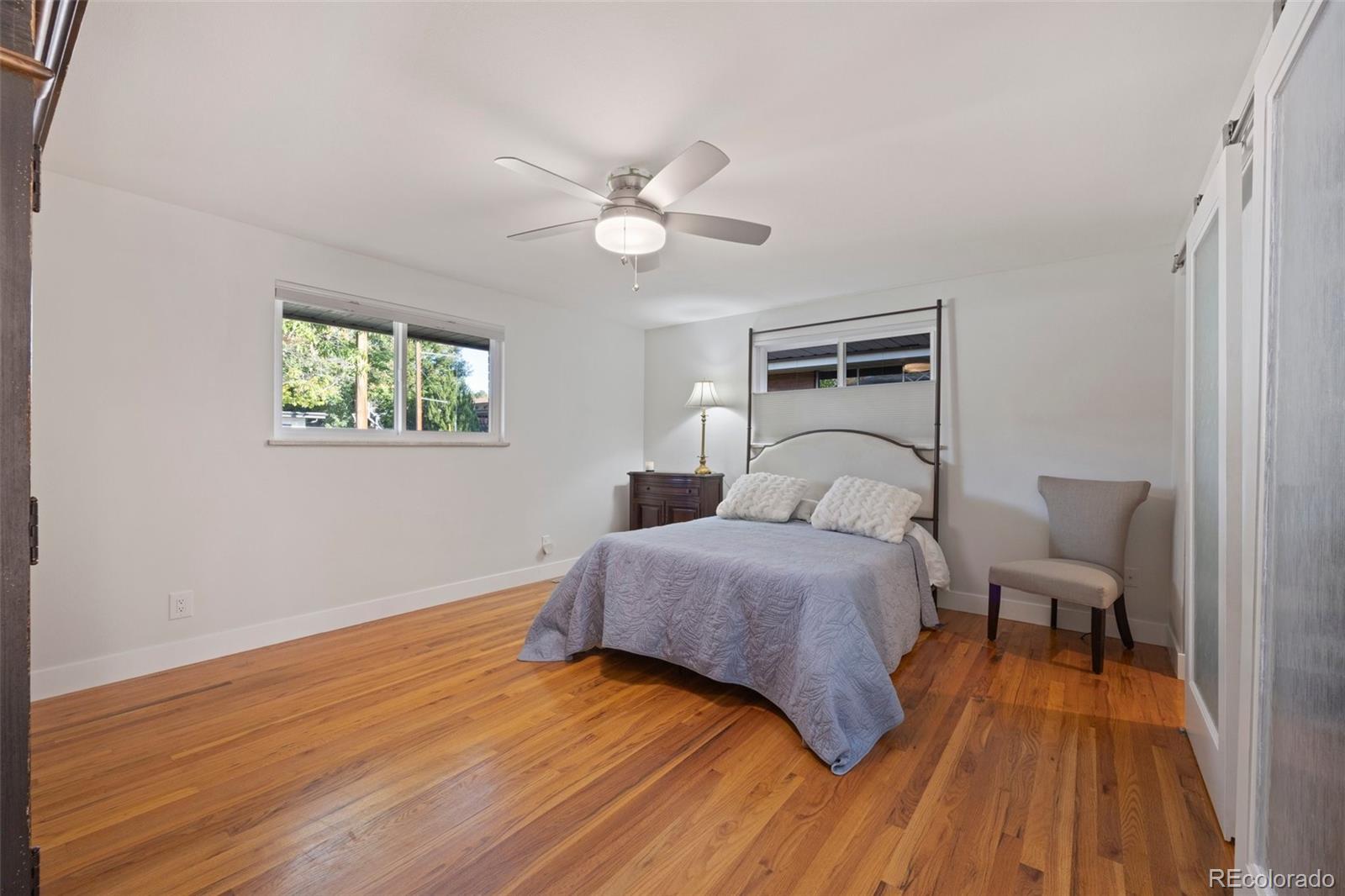 703 South Oneida Way Denver, CO 80224 - Photo 11 of 24 a spacious bedroom with a bed and a chandelier