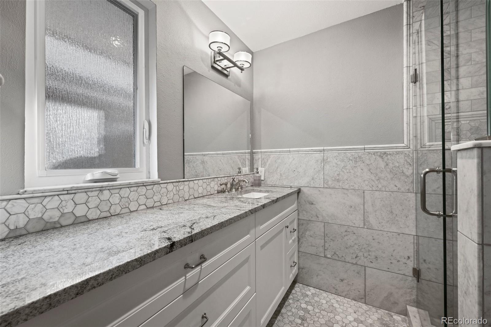703 South Oneida Way Denver, CO 80224 - Photo 13 of 24 a bathroom with a granite countertop sink and a mirror