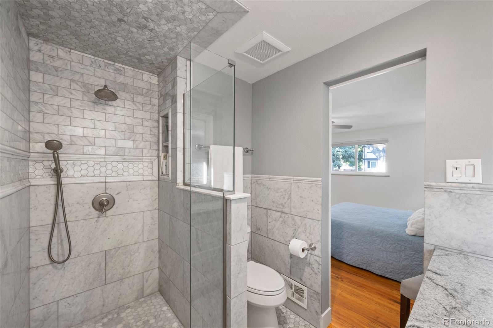 703 South Oneida Way Denver, CO 80224 - Photo 14 of 24 a bathroom with a granite countertop bathtub shower sink and toilet