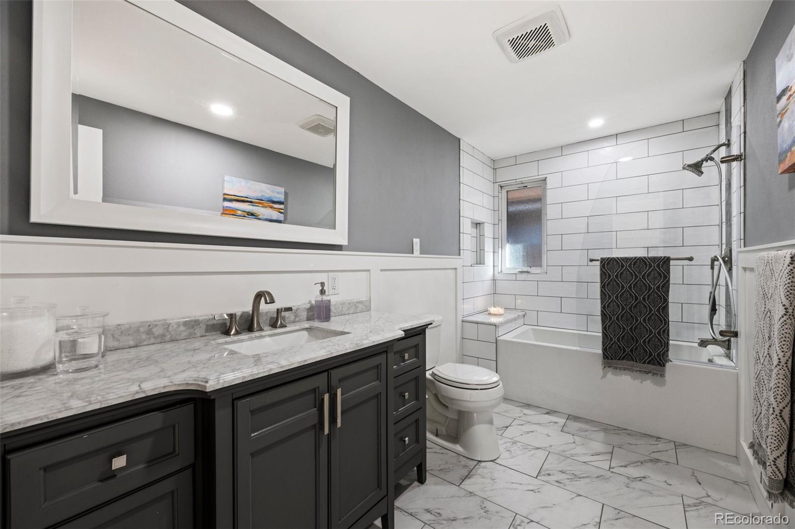 703 South Oneida Way Denver, CO 80224 - Photo 17 of 24 a bathroom with a granite countertop toilet sink and mirror