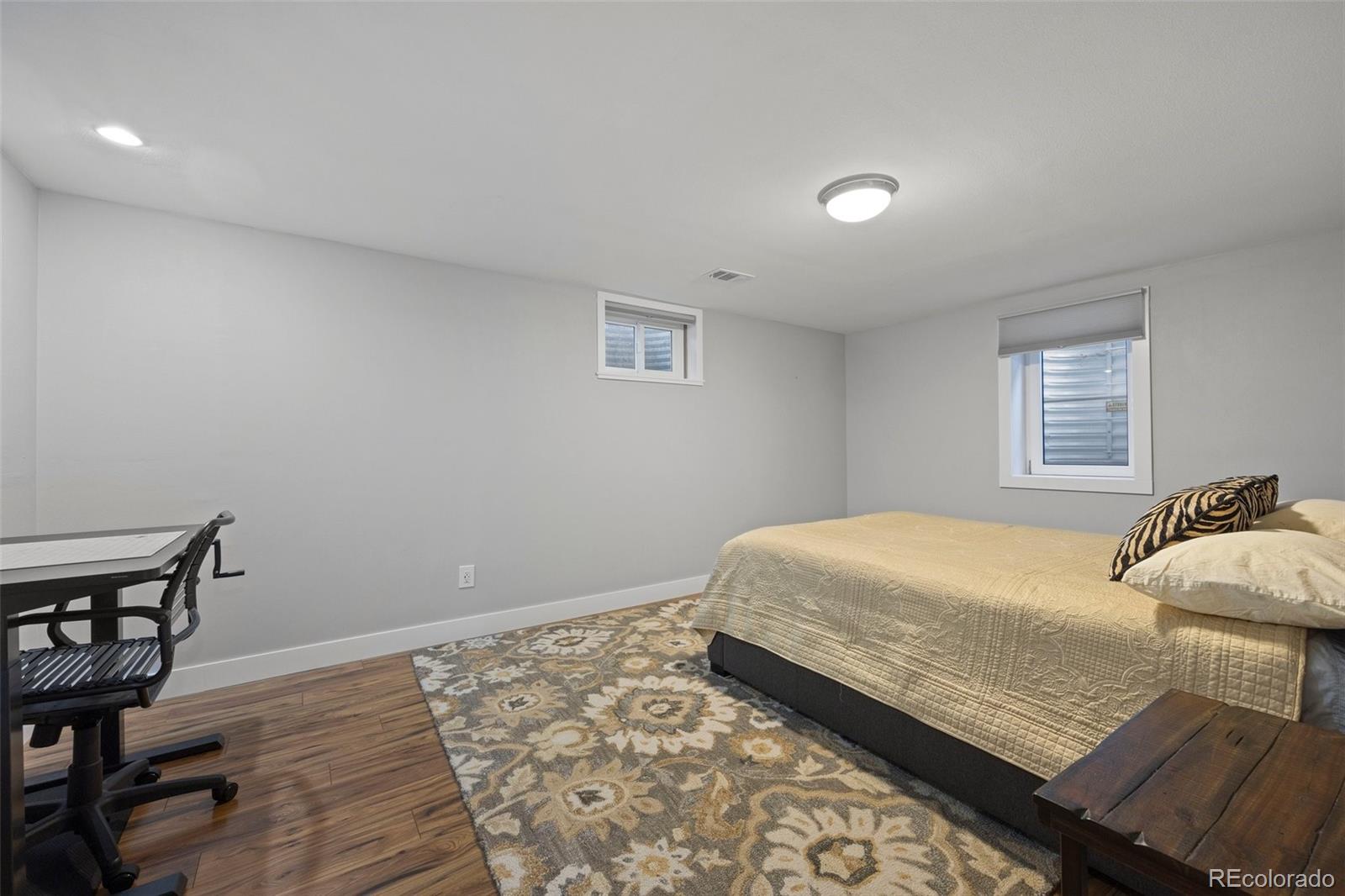 703 South Oneida Way Denver, CO 80224 - Photo 19 of 24 a bedroom with a bed and wooden floor