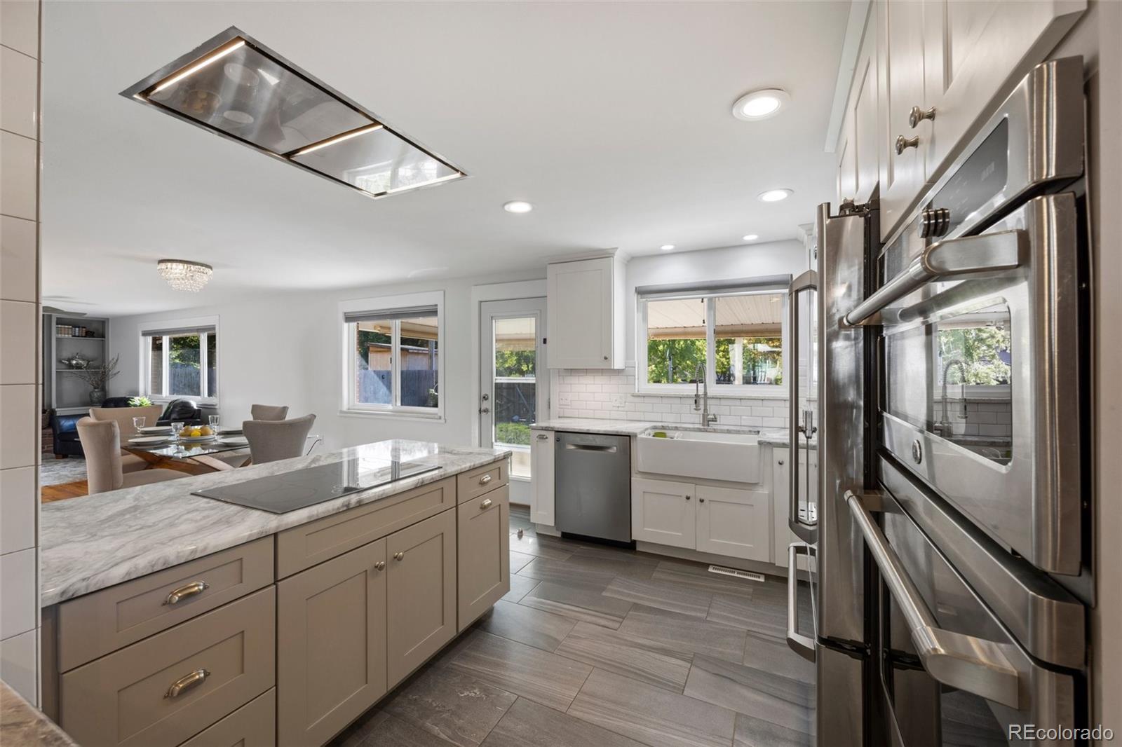 703 South Oneida Way Denver, CO 80224 - Photo 5 of 24 a kitchen with sink cabinets and wooden floor