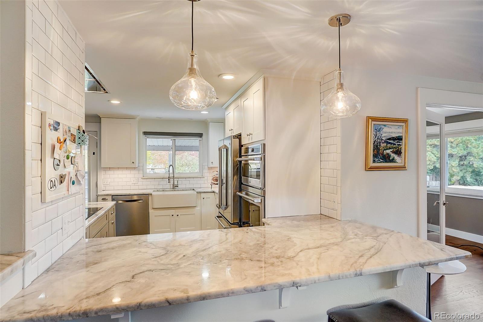 703 South Oneida Way Denver, CO 80224 - Photo 6 of 24 a kitchen with a refrigerator a sink and a stove