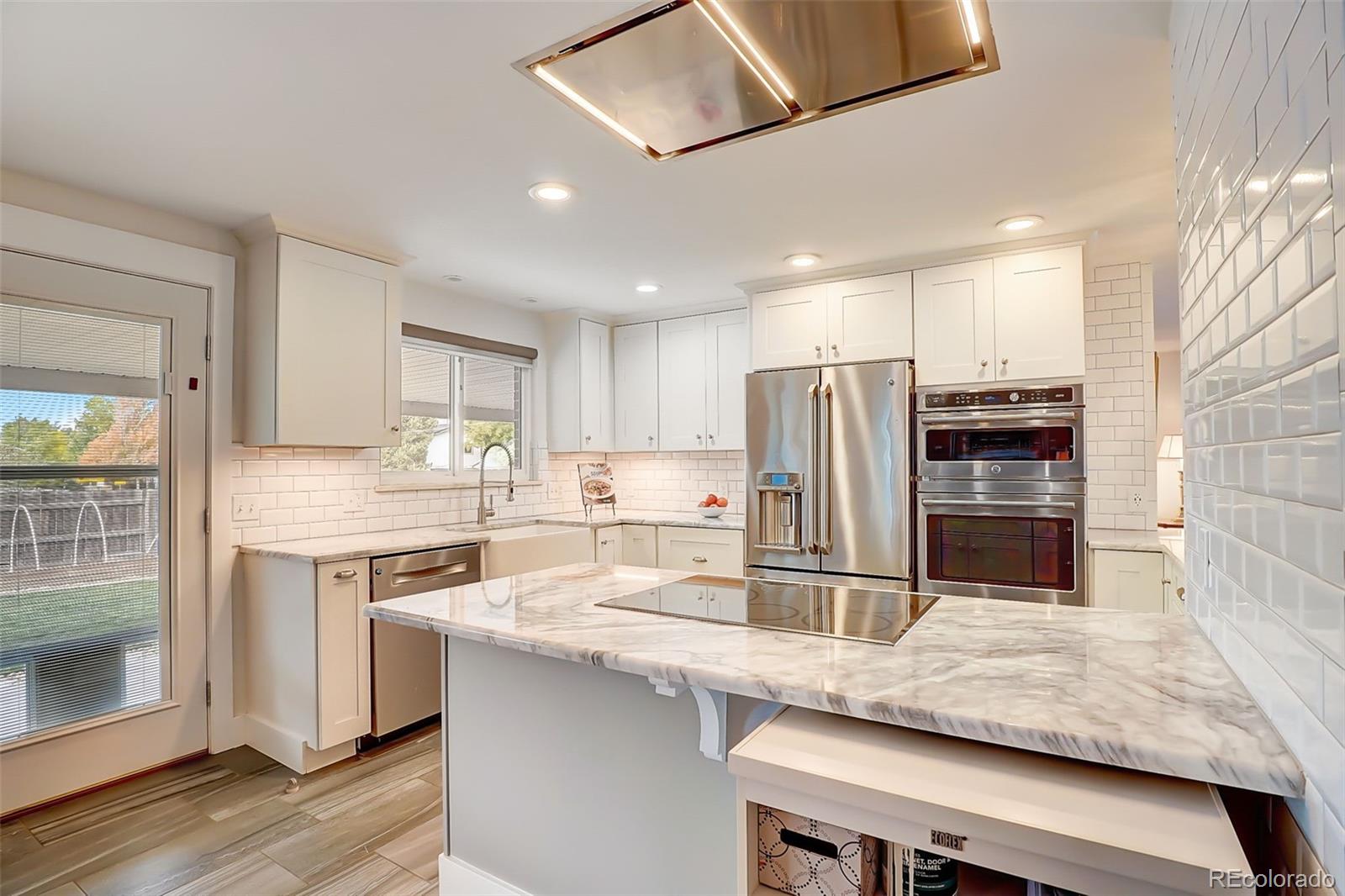 703 South Oneida Way Denver, CO 80224 - Photo 7 of 24 a kitchen with stainless steel appliances granite countertop a sink stove and refrigerator