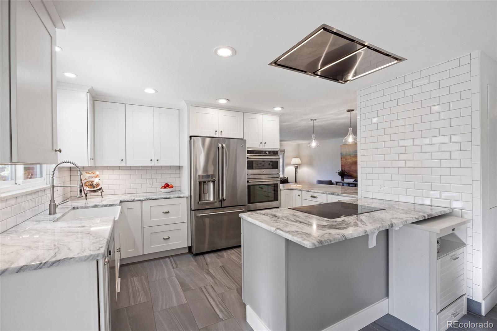 703 South Oneida Way Denver, CO 80224 - Photo 8 of 24 a kitchen with stainless steel appliances granite countertop a sink stove and refrigerator