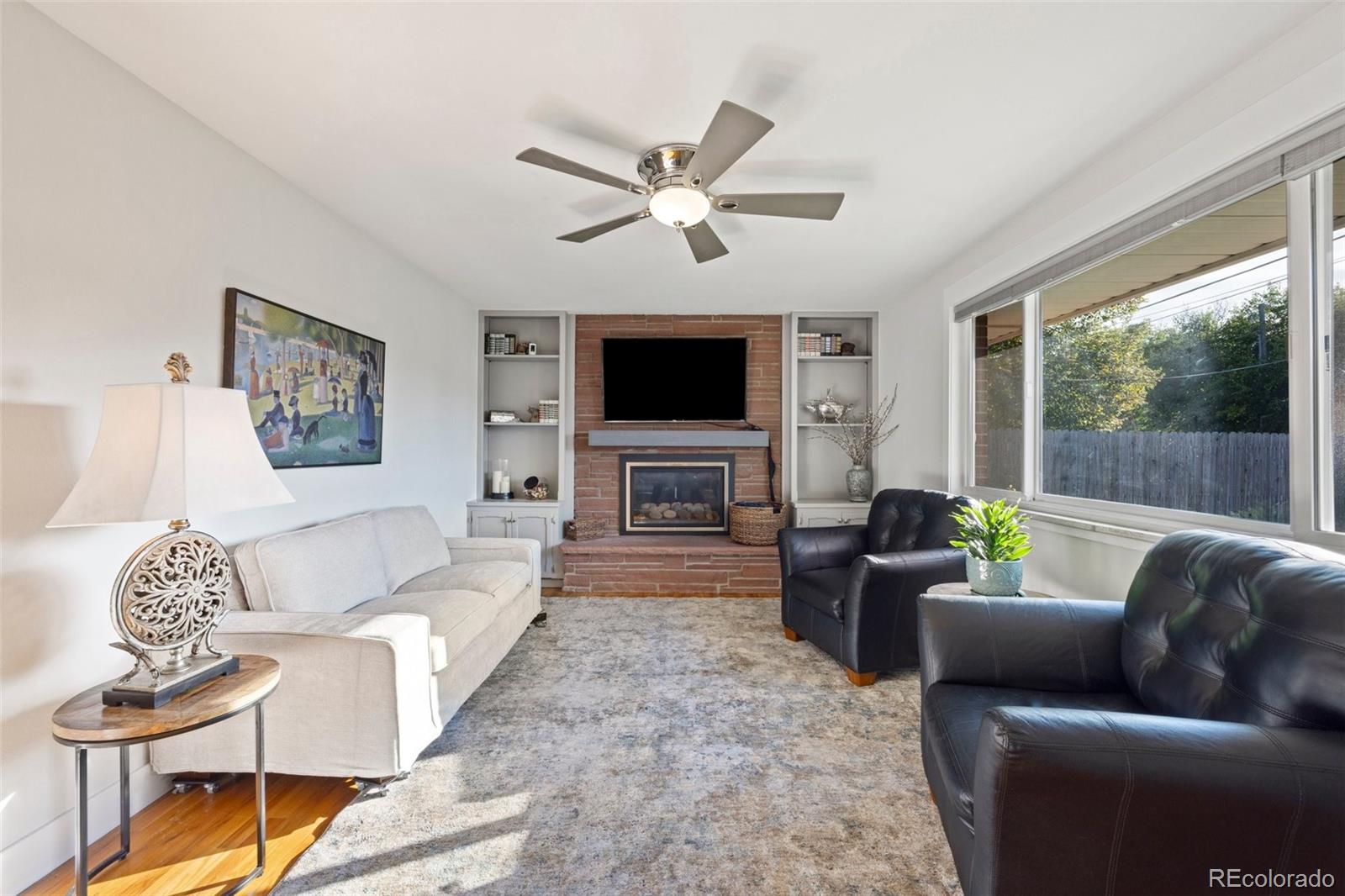 703 South Oneida Way Denver, CO 80224 - Photo 10 of 24 a living room with furniture a fireplace and a flat screen tv