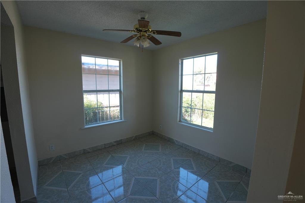 1006 East 23rd Street Weslaco, TX 78596 - Photo 8 of 9 an empty room with windows and fan