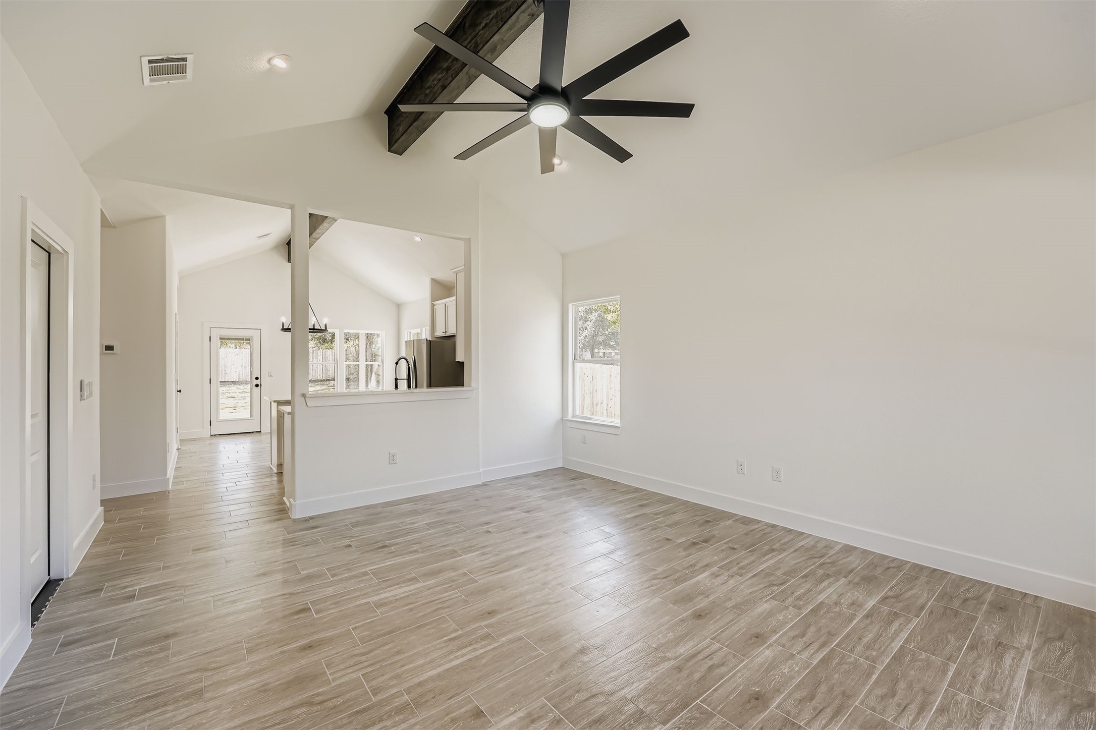 701 East 3rd Street Elgin, TX 78621 - Photo 8 of 35 Bright living room with large windows, vaulted ceiling, and ceiling fan
