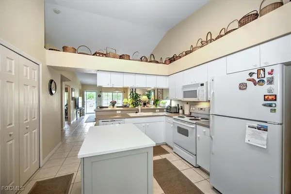 a kitchen with white cabinets and white appliances