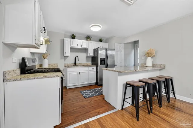 a kitchen with stainless steel appliances a white table and chairs in it