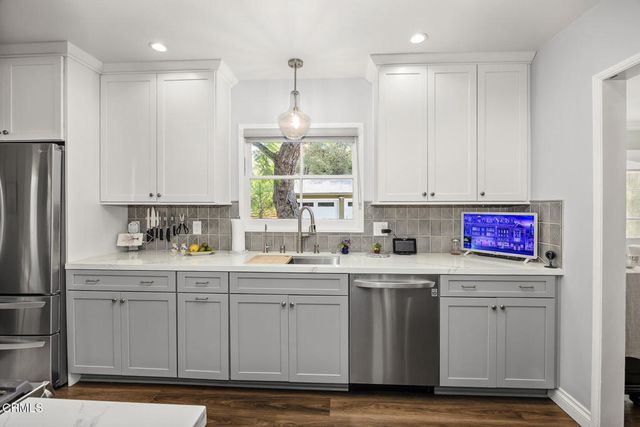 a kitchen with a stove and wooden floor