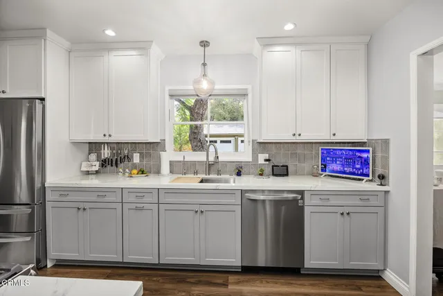 a kitchen with a stove and wooden floor