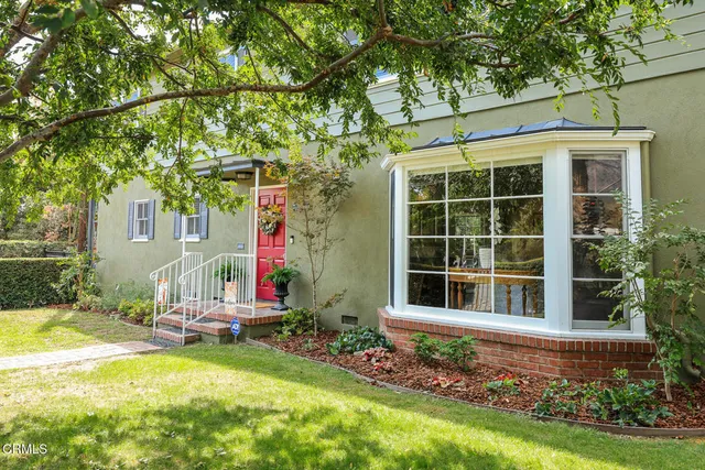 a view of a house with backyard sitting area and garden