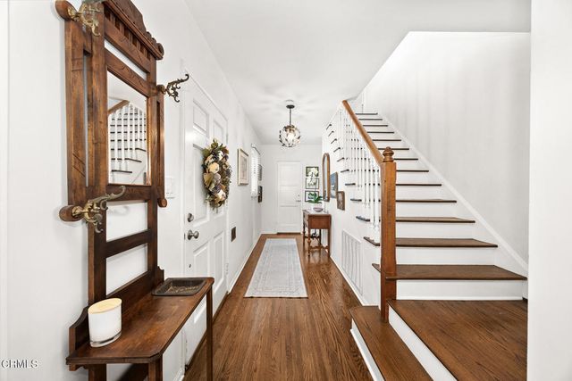 a view of a hallway with wooden floor and staircase