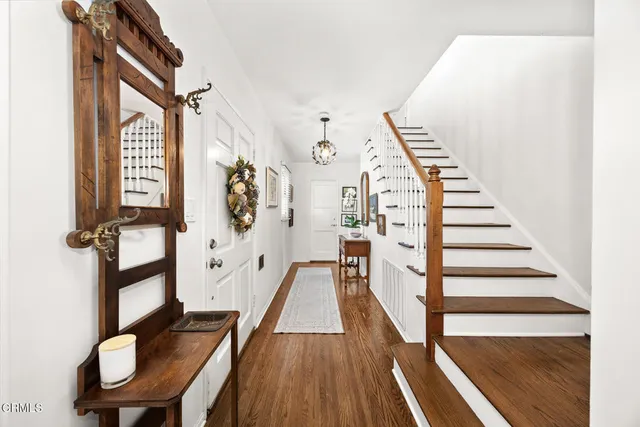 a view of a hallway with wooden floor and staircase