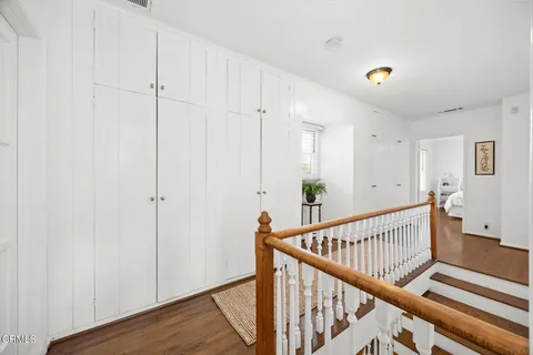 a view of a hallway with wooden floor and staircase