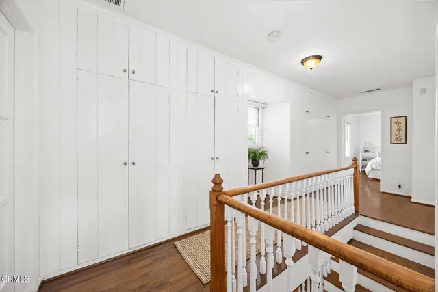 a view of a hallway with wooden floor and staircase