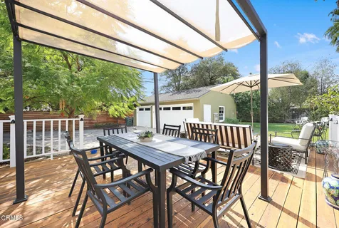 a view of a yard in front of a house with a large tree