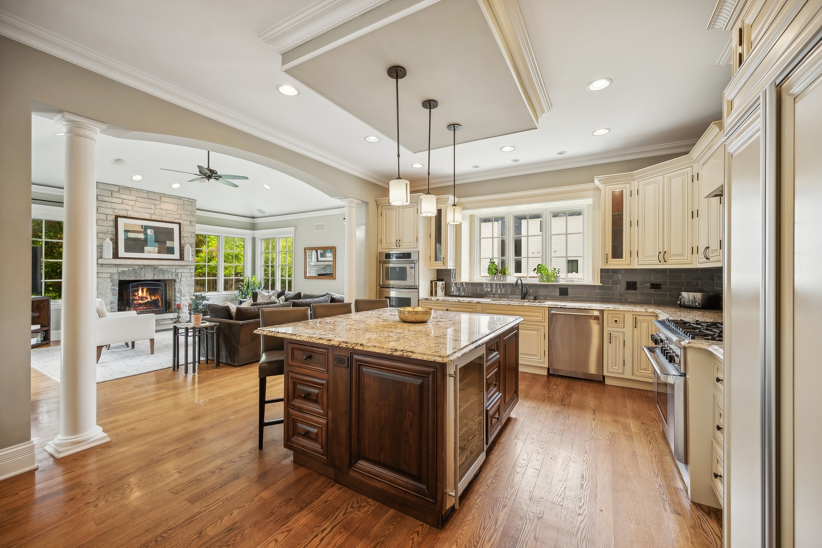 2548 Glenview Road Glenview, IL 60025 - Photo 12 of 39 a kitchen with kitchen island a stove a sink a refrigerator and chairs with wooden floor