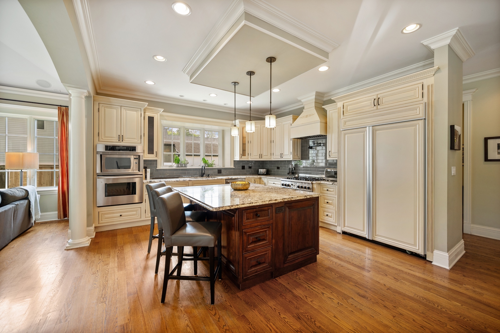 2548 Glenview Road Glenview, IL 60025 - Photo 14 of 39 a large kitchen with stainless steel appliances granite countertop a stove a refrigerator a sink dishwasher and a dining table with wooden floor