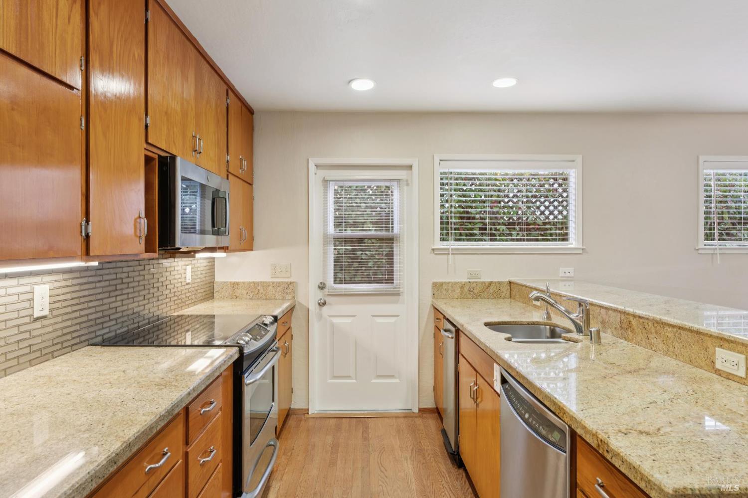 561 Olive Avenue Novato, CA 94945 - Photo 18 of 50 a kitchen with granite countertop a sink stove and cabinets