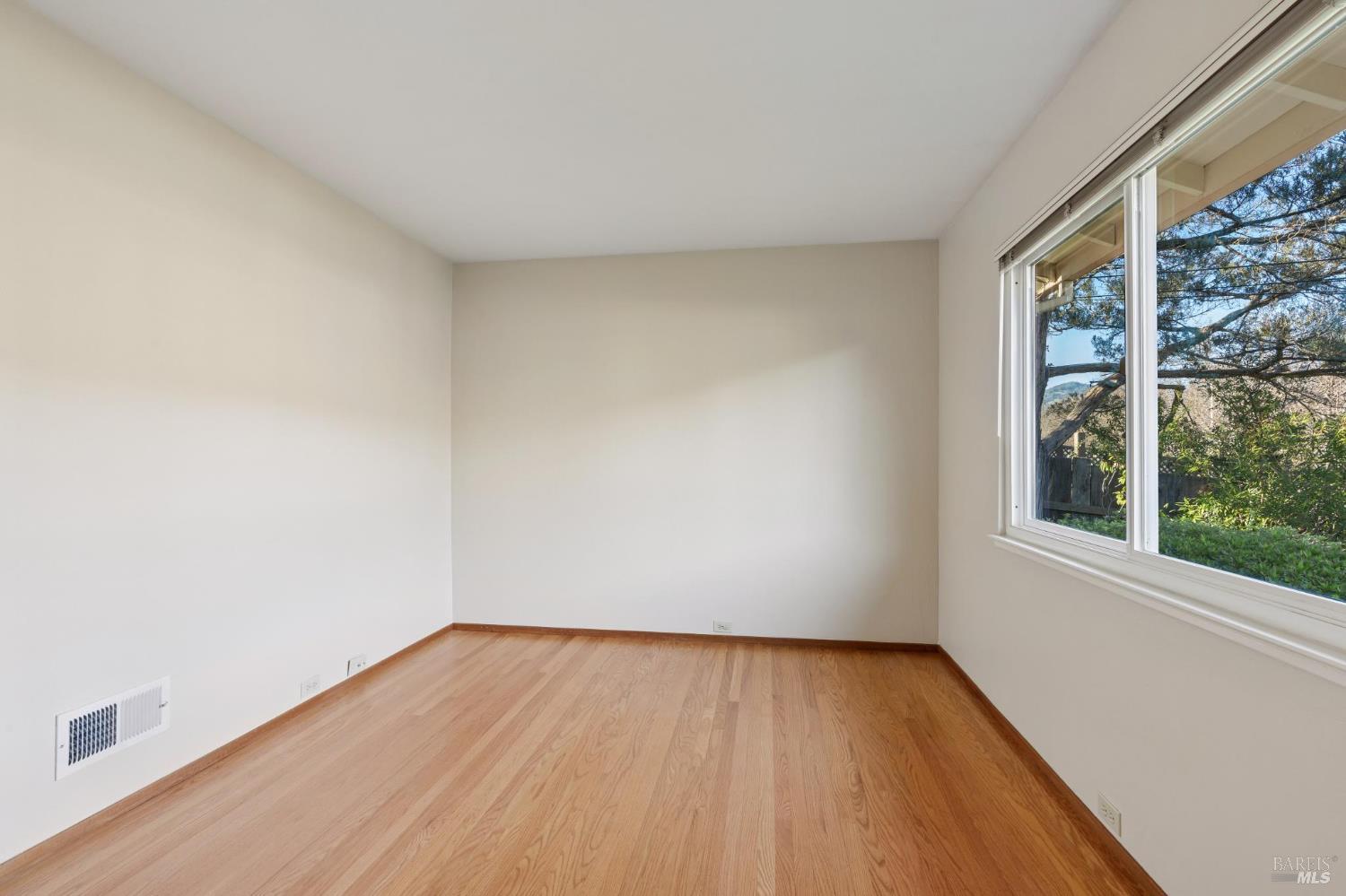 561 Olive Avenue Novato, CA 94945 - Photo 29 of 50 an empty room with wooden floor and windows