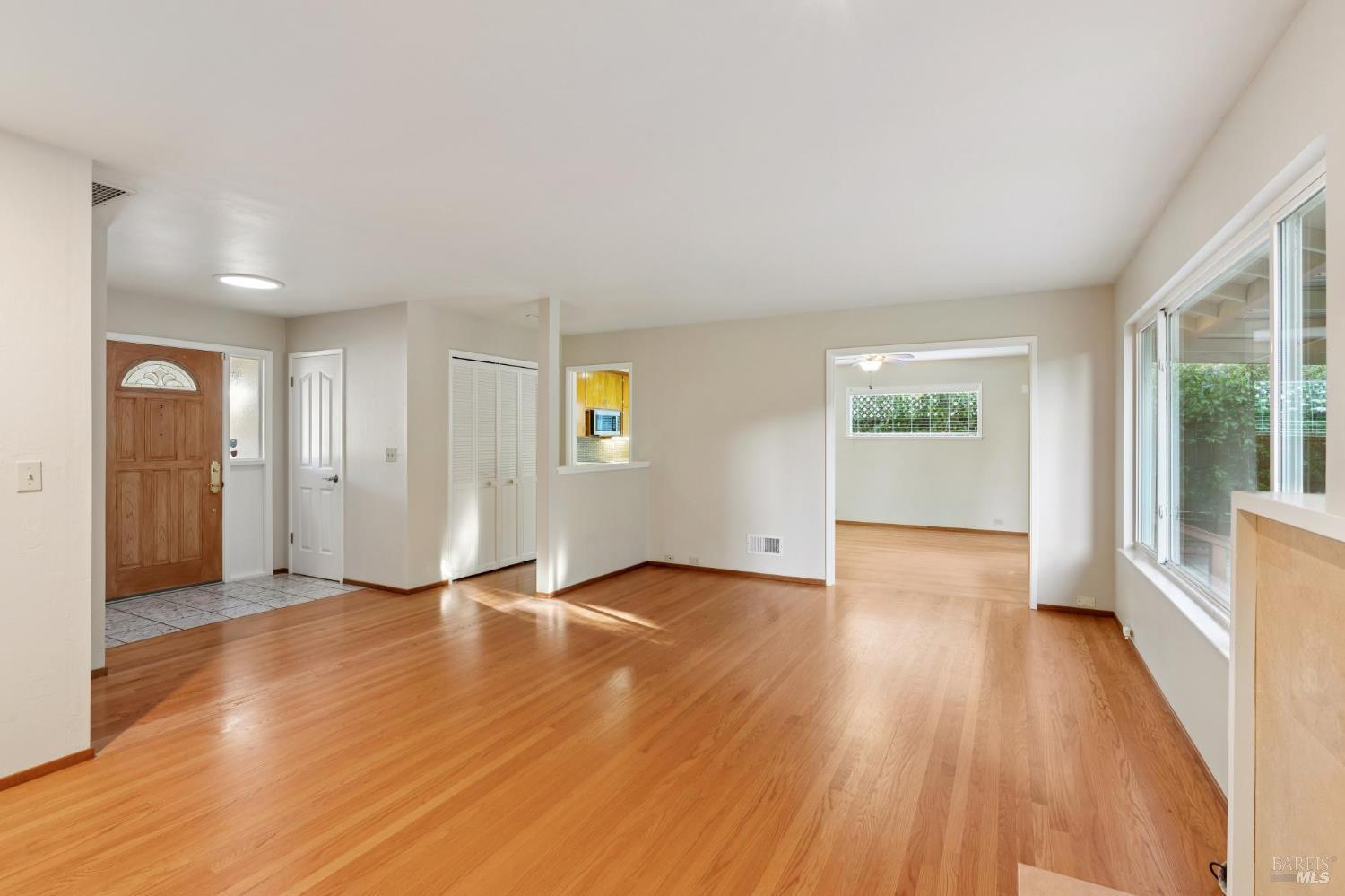 561 Olive Avenue Novato, CA 94945 - Photo 8 of 50 an empty room with wooden floor and windows