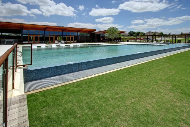 a view of a lake with a big yard and large trees