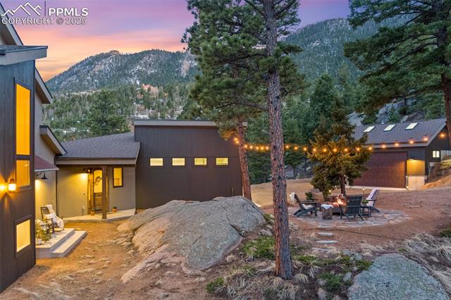 5995 Waterfall Road Manitou Springs, CO 80829 - Photo 4 of 13 Front yard with naturally placed boulders, fire pit and a front shot of the detached garage/workshop. VIEWS!