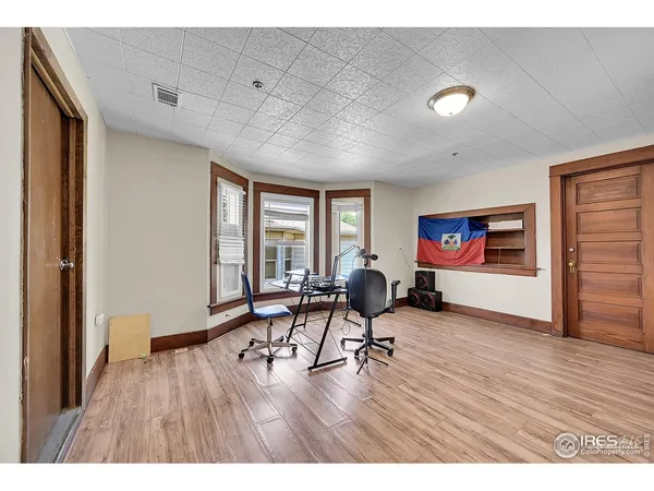 a living room with furniture floor to ceiling window and wooden floor