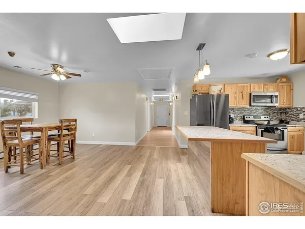 a open kitchen with cabinets wooden floor and stainless steel appliances