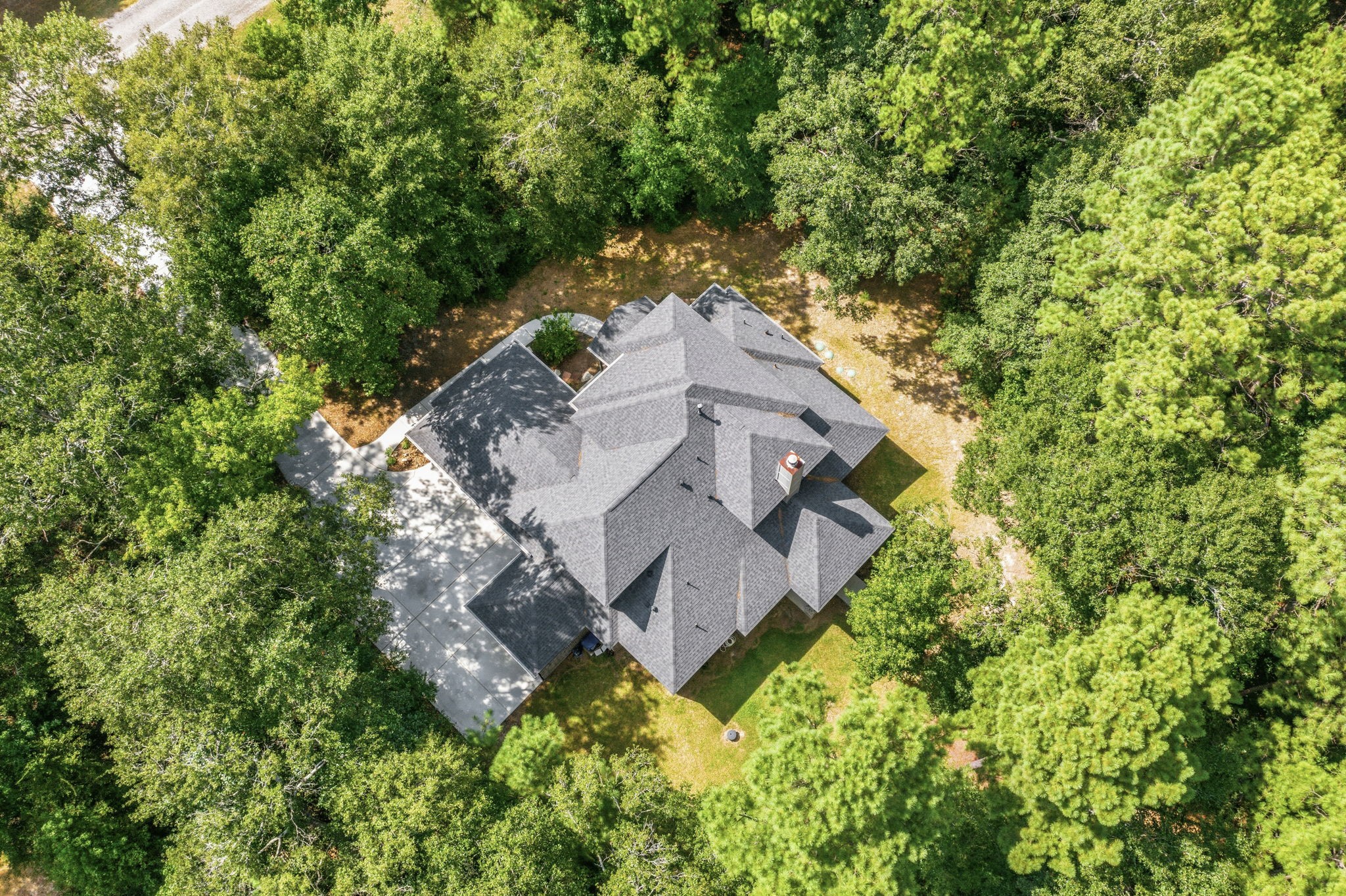 248 Fire Sky Road Huntsville, TX 77340 - Photo 36 of 36 From above, the home is beautifully tucked among mature trees, illustrating the exceptional privacy and natural setting of this 2.3-acre property.