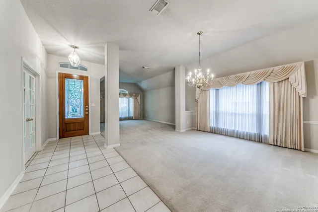 a view of an empty room with window and fire place