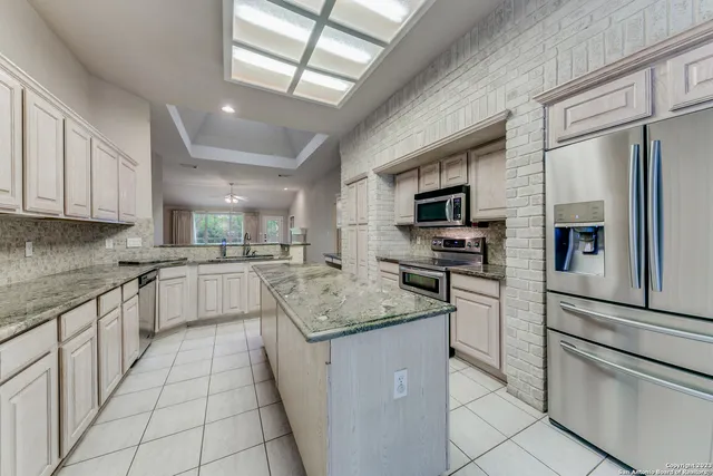 a kitchen with stainless steel appliances granite countertop a stove a sink and a microwave