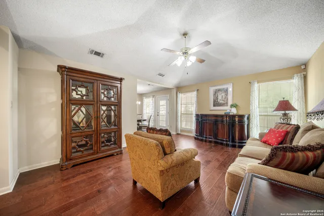 a living room with furniture ceiling fan and a wooden floor