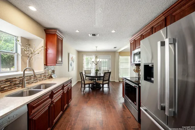 a kitchen with stainless steel appliances granite countertop a sink stove and refrigerator