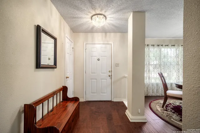 a view of a hallway with wooden floor and furniture