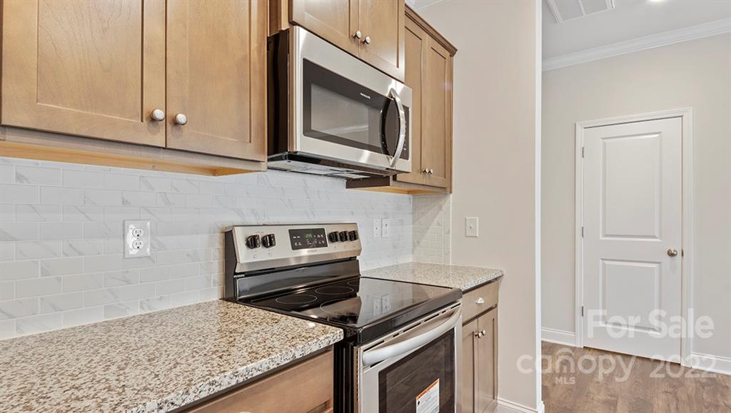 67 Creekview Road Hendersonville, NC 28792 - Photo 9 of 25 a kitchen with granite countertop a stove and a microwave