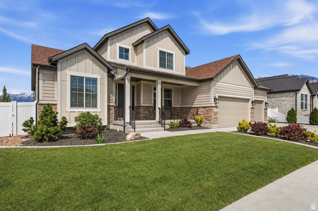 1434 West Stable Street Lindon, UT 84042 - Photo 4 of 76 AI enhanced lawn. Craftsman-style home with board and batten siding, a porch, stone siding, an attached garage, and a shingled roof