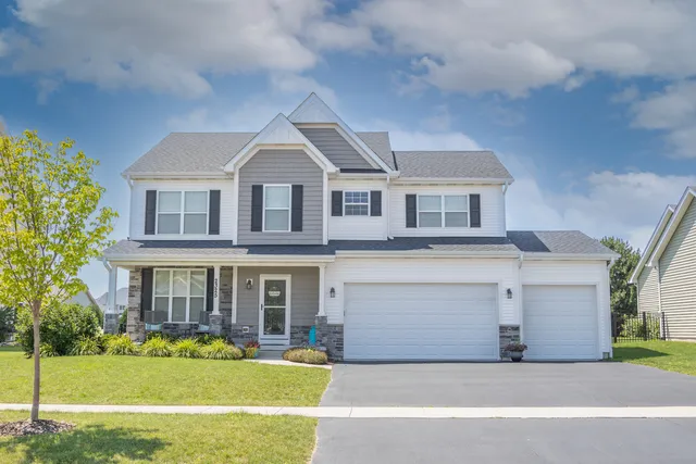a front view of a house with a garden and yard
