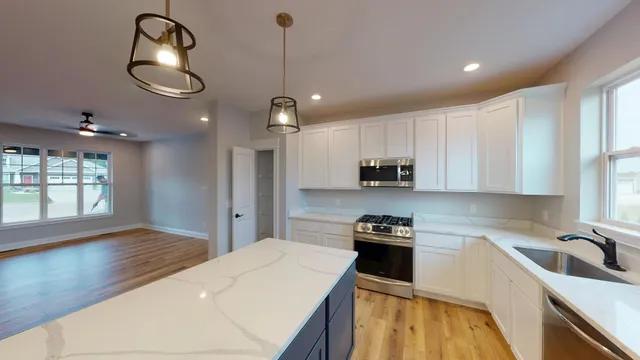 a kitchen that has a lot of cabinets and wooden floor