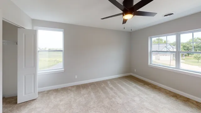 a view of an empty room and window and chandelier fan