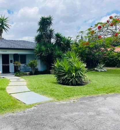 a view of a house with a garden and pathway